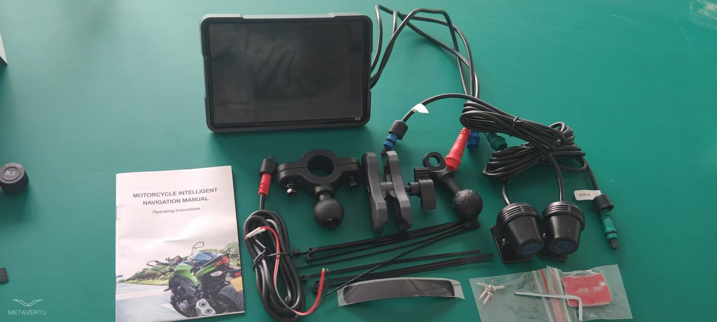 Motorcycle wireless navigation device components including a screen, mounts, cables, and user manual on a green surface.